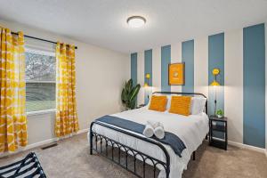 een slaapkamer met een bed met gele en blauwe strepen bij *New* Cozy / Near MTSU / Getaway ~ Sleeps 8+ in Murfreesboro