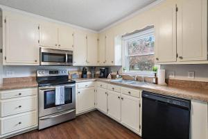 een keuken met witte kasten en een spoelbak bij *New* Cozy / Near MTSU / Getaway ~ Sleeps 8+ in Murfreesboro