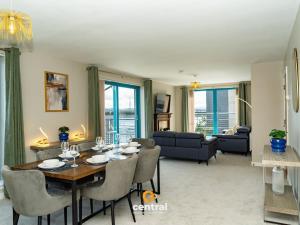 a dining room and living room with a table and chairs at CENTRAL SERVICED APARTMENTS - City Quay - 2 Bedrooms - En-Suite Bathroom - Dedicated Parking Space - Fully Equipped - Walk Away From Dundee Bus & Train Station - Close to City Centre with River Views and Balcony - NEW in Dundee