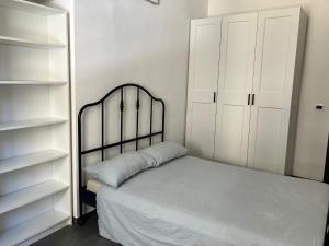 a bedroom with a bed and white shelves at Porta Susa Rooms in Turin
