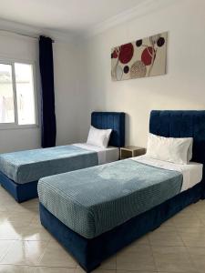 two beds in a room with two blue beds at corniche de Malabata in Tangier