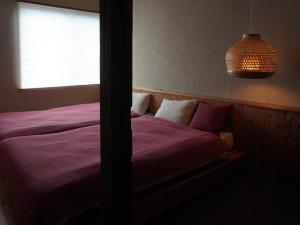 a bedroom with a purple bed with a window at suo Camellia Island Inn - Vacation STAY 95452v in Oshima