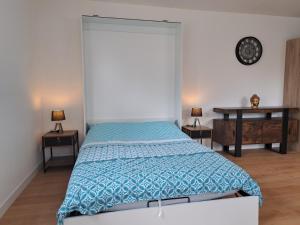 a bedroom with a bed with a blue comforter at le studio d isa in Lens