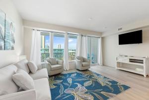 a living room with a couch and chairs and a tv at Sea Glass Unit 209 in Gulf Shores