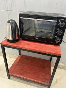 eine Mikrowelle auf einem Holztisch in der Unterkunft Departamento Rojas 2 in San Fernando del Valle de Catamarca
