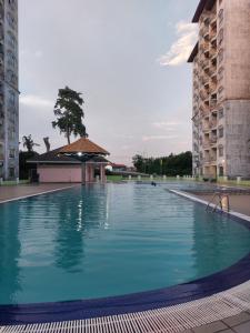 a large swimming pool between two tall buildings at Port Dickson Sunshine Resort in Port Dickson