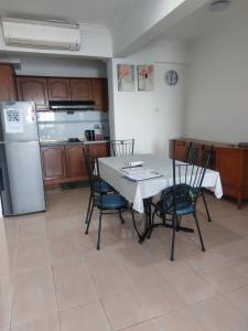 a kitchen with a table and chairs and a refrigerator at Port Dickson Sunshine Resort in Port Dickson