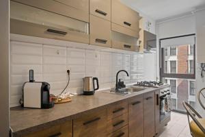 a kitchen with wooden cabinets and a sink and a counter at Greenplace in Bucharest