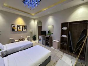 a bedroom with two beds and a chandelier at Nuzul R182 - Elegant Studio in Riyadh