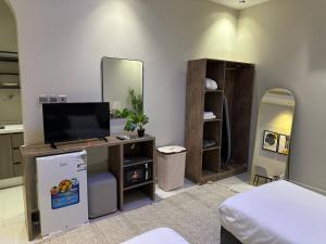 a living room with a tv and a mirror at Nuzul R182 - Elegant Studio in Riyadh