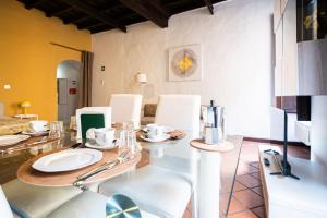 una sala da pranzo con un tavolo di vetro e sedie bianche di Persia Collection Ripetta a Roma