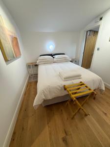 a bedroom with a large bed with a wooden floor at The Old Pub Unique Modern Extra Large Private Cellar with Sauna Gym King Size Bed Snacks Mini Bar and Continental Breakfast Fully Self Contained in Patney