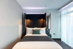 a bedroom with a large bed with a black headboard at Point A Hotel Edinburgh Haymarket in Edinburgh +36 photos