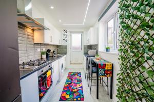 a kitchen with a colorful rug on the floor at Unique and Bright 6 Bedrooms Home Retreat - Fast WiFi - Close to Amenities in Cardiff
