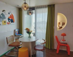a room with a table and chairs and a window at Yeosu Ubless Gami Stay in Yeosu