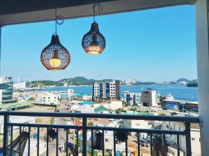 a view of a city from a balcony with two lights at Yeosu Ubless Gami Stay in Yeosu