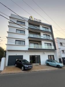 two cars parked in front of a building at PalissHotel in Faravohitra +7 photos
