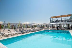 a large swimming pool with lounge chairs and umbrellas at Capsis Hotel Thessaloniki in Thessaloniki