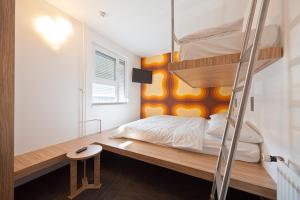 a bedroom with a bunk bed with a ladder at Bit Center Hotel in Ljubljana