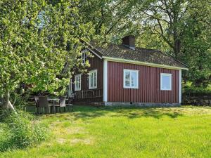a red house with a table and chairs in a yard at 4 star holiday home in kode in Kode