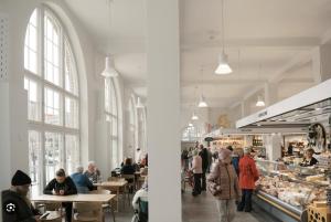 un groupe de personnes assises à des tables dans une boulangerie dans l'établissement Luxurious 85m2 Hakaniemi, Helsinki Center, Apartment Next to Metro, à Helsinki