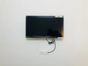 a flat screen tv hanging on a white wall at Nelis Guest House in Bogmalo