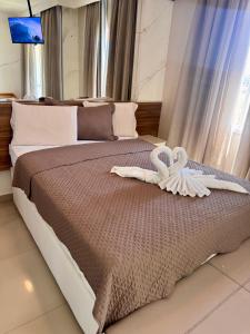 a bedroom with a bed with two swans on it at VG FUN Praia do Futuro Pé na Areia ap 311 IMOB TEMPORADA in Fortaleza +37 photos