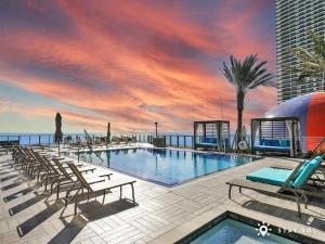 a swimming pool on a building with a sunset at Rooftop Pool Oceanview Balcony & Beachfront Resort in Hollywood Beach