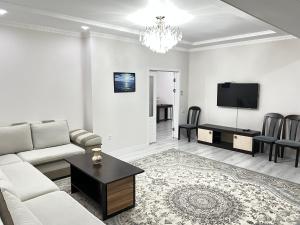 a white living room with a couch and a table at Djal in Bishkek