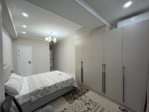 a bedroom with a bed and a white cabinet at Djal in Bishkek