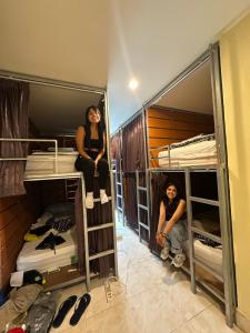 查汶Tnon Samui Hostel的坐在双层床上的一个男人和一个女人