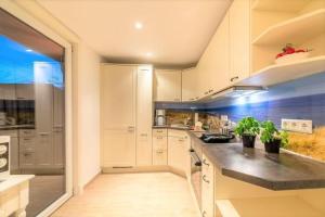 a kitchen with white cabinets and black counter tops at Strandgut EG in Morsum