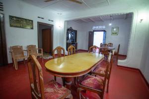 a dining room with a wooden table and chairs at Relax Holiday Home in Ahangama