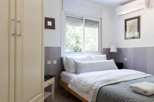 a bedroom with a bed with white sheets and a window at Sisso in the green north of Israel tivon Valley in Tiv‘on +7 photos