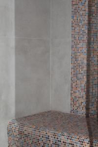 a corner of a shower with a tiled wall at Twinssuites - Adults only in Limone sul Garda