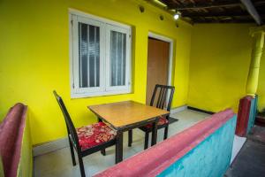 a table and chairs in a room with a yellow wall at Relax Holiday Home in Ahangama