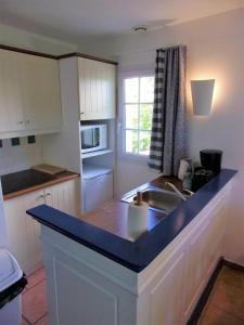 a kitchen with a sink and a counter top at Bright 50 M For 6 With Balcony And Garden in Moliets-et-Maa