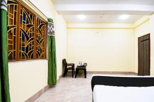 ein Zimmer mit einem Bett und einem Tisch mit einem Stuhl in der Unterkunft Hotel O HIGHWAY STAY IN in Bhubaneshwar
