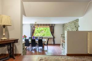una sala da pranzo con tavolo, sedie e una finestra di VILLA NINFEO 10&4, Emma Villas ad Arezzo