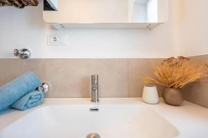 a bathroom sink with a blue towel on it at Jan's Apartment am See in Pracupola +29 photos