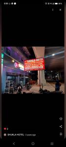 a sign for a hotel with motorcycles parked in a parking lot at Shukla Hotel in Kānpur