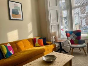 - un salon avec un canapé jaune et des oreillers colorés dans l'établissement 3-Bed Home Close to City Centre, Stadium & Baltic, à Newcastle upon Tyne