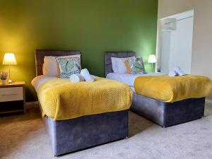 - 2 lits dans une chambre dotée d'un mur vert dans l'établissement 3-Bed Home Close to City Centre, Stadium & Baltic, à Newcastle upon Tyne