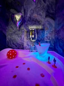 ein Zimmer mit einem rosa beleuchteten Zimmer mit einem Waschbecken und einer Badewanne in der Unterkunft Altopiano Rooms Suite in Foggia