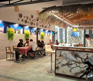 a group of people sitting at tables in a restaurant at So Cute Hostel, Kai Bae, Koh Chang in Trat