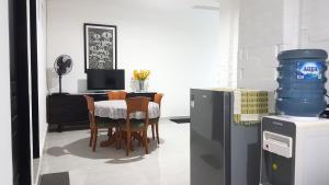 una sala da pranzo con tavolo, sedie e frigorifero di Rumah Benhil, Bendungan Hilir - Senayan a Giacarta