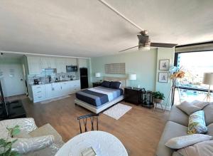 a living room with a bed and a kitchen at Spectacular Oceanfront Studio w/kitchenette in Daytona Beach