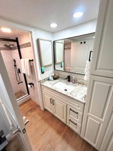 a bathroom with a sink and a large mirror at Spectacular Oceanfront Studio w/kitchenette in Daytona Beach