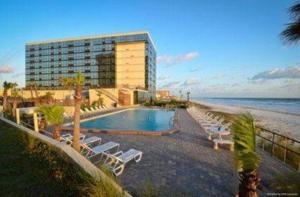 a resort with a swimming pool and a building and the beach at Spectacular Oceanfront Studio w/kitchenette in Daytona Beach