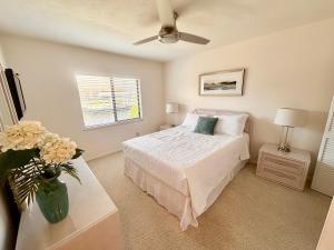 a bedroom with a bed and a vase of flowers on a table at Pirates Cove Marco Island, saltwater pool, bikes, water sports, paddle boards included! in Marco Island +40 photos